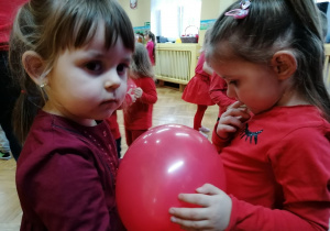 Dziewczynki tańczą z balonem między sobą