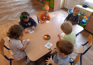 Dzieci stemplują palcami maczanymi w farbie obrazek wybranego owocu