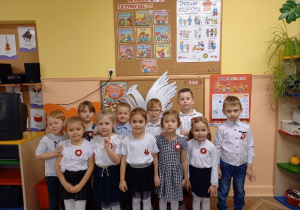 Grupa dzieci w odświętnych strojach pozuje do zdjęcia