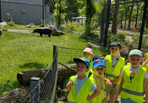Grupa dzieci stoi obok wybiegu dla hipopotamów