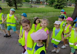 Grupa dzieci spaceruje alejką w zoo