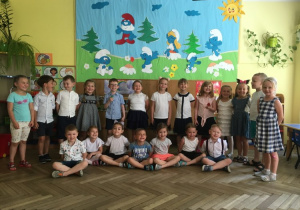 Dzieci ubrane odświętnie pozują do zdjęcia