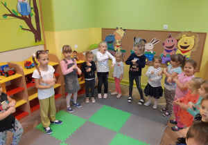 Dzieci tańczą w kole do utworu muzycznego
