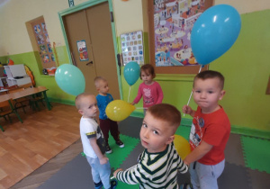 Dzieci z balonami tańczą w kole