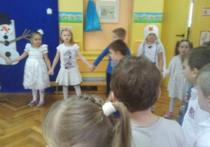 Dzieci stoją w kole trzymając się za ręce