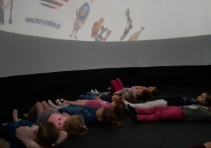 Dzieci leżą w namiocie czekając na pokaz
