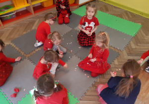 Dzieci zbierają z ziemi serduszkowe confetti