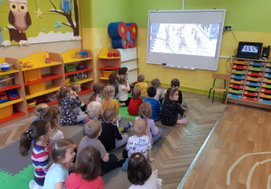 Dzieci oglądają prezentację multimedialną dotyczącą zimowych igrzysk olimpijskich