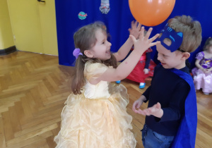 Dwójka dzieci tańczy z balonem