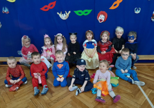 Dzieci pozują do zdjęcia na tle karnawałowej dekoracji