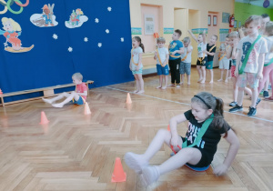 Dzieci naśladują jazdę na sankach