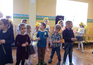 Dzieci stoją w dwóch kołach trzymając w ręku kwiat