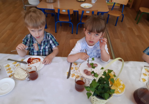 Dzieci jedzą wielkanocne śniadanko przy wspólnym stole