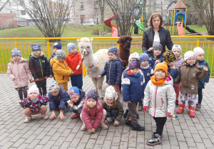 Dzieci pozują do zdjęcia z alpakami