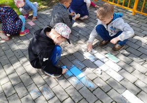 Dzieci rysują kredą na tarasie