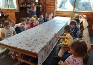 Dzieci siedzą przy długim stole