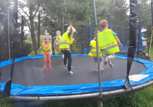 Dzieci skaczą na trampolinie