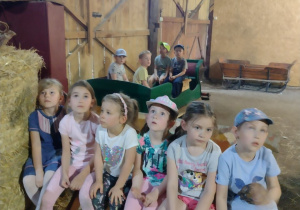 Dzieci siedzą w stodole