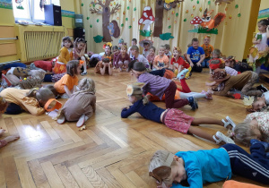 Dzieci kładą się na podłodze - naśladują zwierzęta, o których mowa w piosence