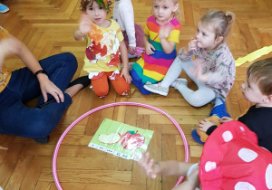 Dzieci z grupy maluszków składają z części obrazek przedstawiający jabłko