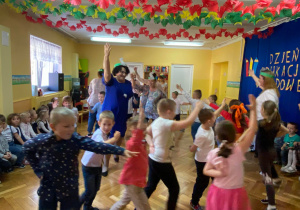 Dzieci wspólnie z paniami tańczą krakowiaka