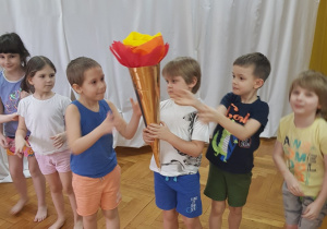 Dzieci podają sobie znicz olimpijski